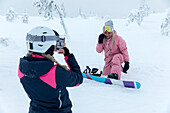 Frauen, die beim Snowboarden ein Foto machen