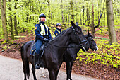 Polizistinnen auf Pferden im Wald