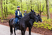 Policewomen on horses in forest