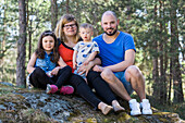 Family of four looking at camera