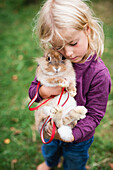 Mädchen umarmt Kaninchen