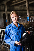 Woman with cow in barn