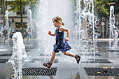 Girl running over fountain