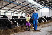 Woman with daughter in cowshed