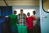 Vater mit Söhnen schaut durch das Zugfenster