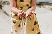 Girls hands holding sand