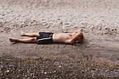 Boy lying on sand