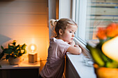 Girl looking through window