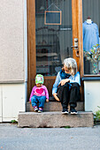 Mutter mit Tochter auf den Stufen sitzend