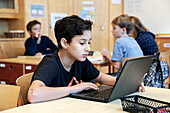 Boy using laptops at school