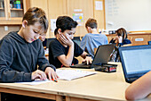 Jungen benutzen Laptops in der Schule