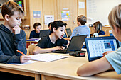 Boys using laptops at school