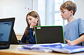 Schülerinnen und Schüler an Laptops