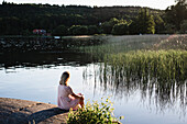 Frau sitzt am See