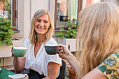 Freundinnen trinken Kaffee in einem Straßencafé