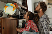Girl with father looking at globe