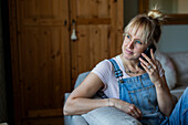 Woman using phone on sofa