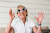 Happy woman wearing star-shaped sunglasses