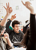 Jugendlicher hebt die Hand im Klassenzimmer