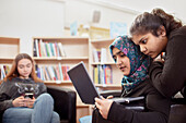 Teenage girls sitting together in library