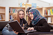 Teenage girls sitting together in library