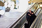 Reifes Paar auf Rolltreppe