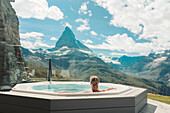 Frau im Whirlpool mit Blick auf die Berge