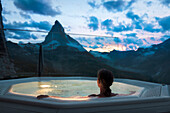 Frau im Whirlpool mit Blick auf die Berge