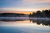 View of foggy lake at sunset