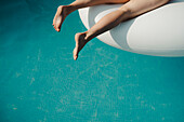 Frauenbeine über Wasser im Schwimmbad