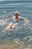 Älterer Mann schwimmt im Meer