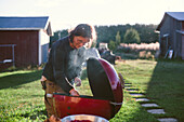 Frau beim Grillen im Garten