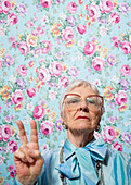 Ältere Frau zeigt Friedenszeichen