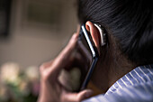 Frau mit Hörgerät beim Telefonieren mit dem Handy