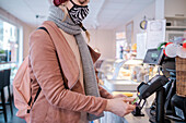 Woman with face mask paying