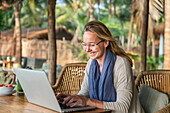 Woman in outdoor cafe using laptop