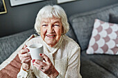 Ältere Frau hält Tasse