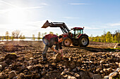 Landwirt entfernt Steine vom Feld