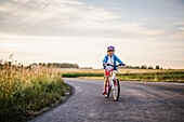 Girl cycling on country road