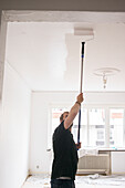 Man painting ceiling