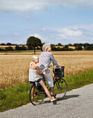 Grandmother cycling with granddaughter