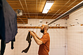 Man hanging laundry in utility room