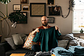 Man in living room folding clothes