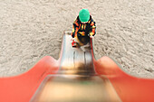 Girl standing on bottom of metal slide
