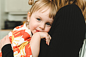 Girl in mothers arms looking at camera