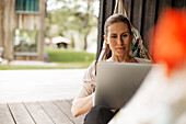 Woman on hammock using laptop