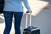 Woman holding suitcase handle