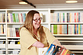 Lächelnde Frau arbeitet in der Bibliothek