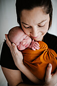 Mother hugging newborn baby