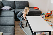 Girl vacuum cleaning living room